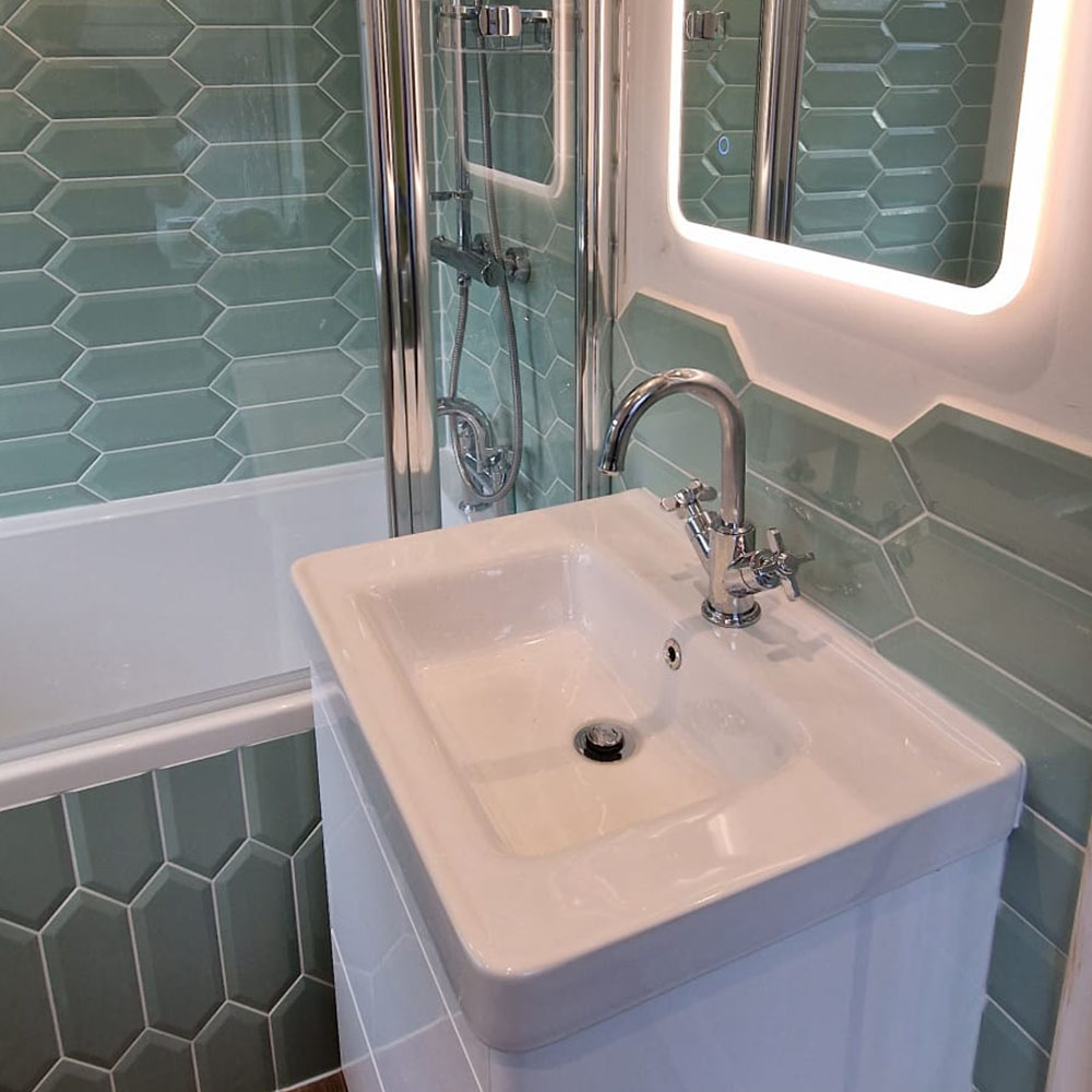 Stylish bathroom with green hexagonal tiles, a modern sink, and chrome fittings, showcasing the craftsmanship of expert bathroom fitters.